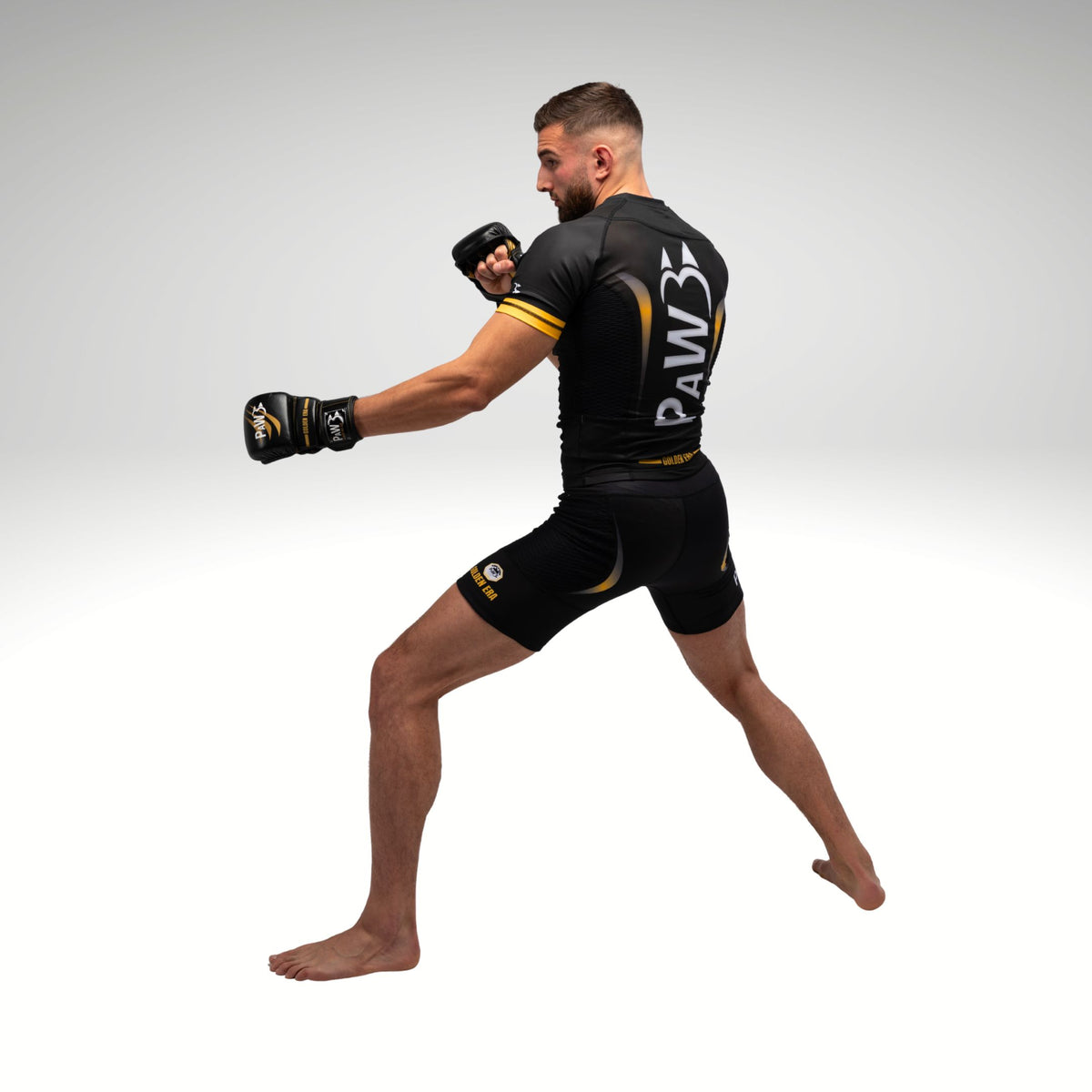 Seitenansicht eines MMA Kämpfers mit PAW Compression Shirt und MMA Handschuhen in Schwarz und Gold