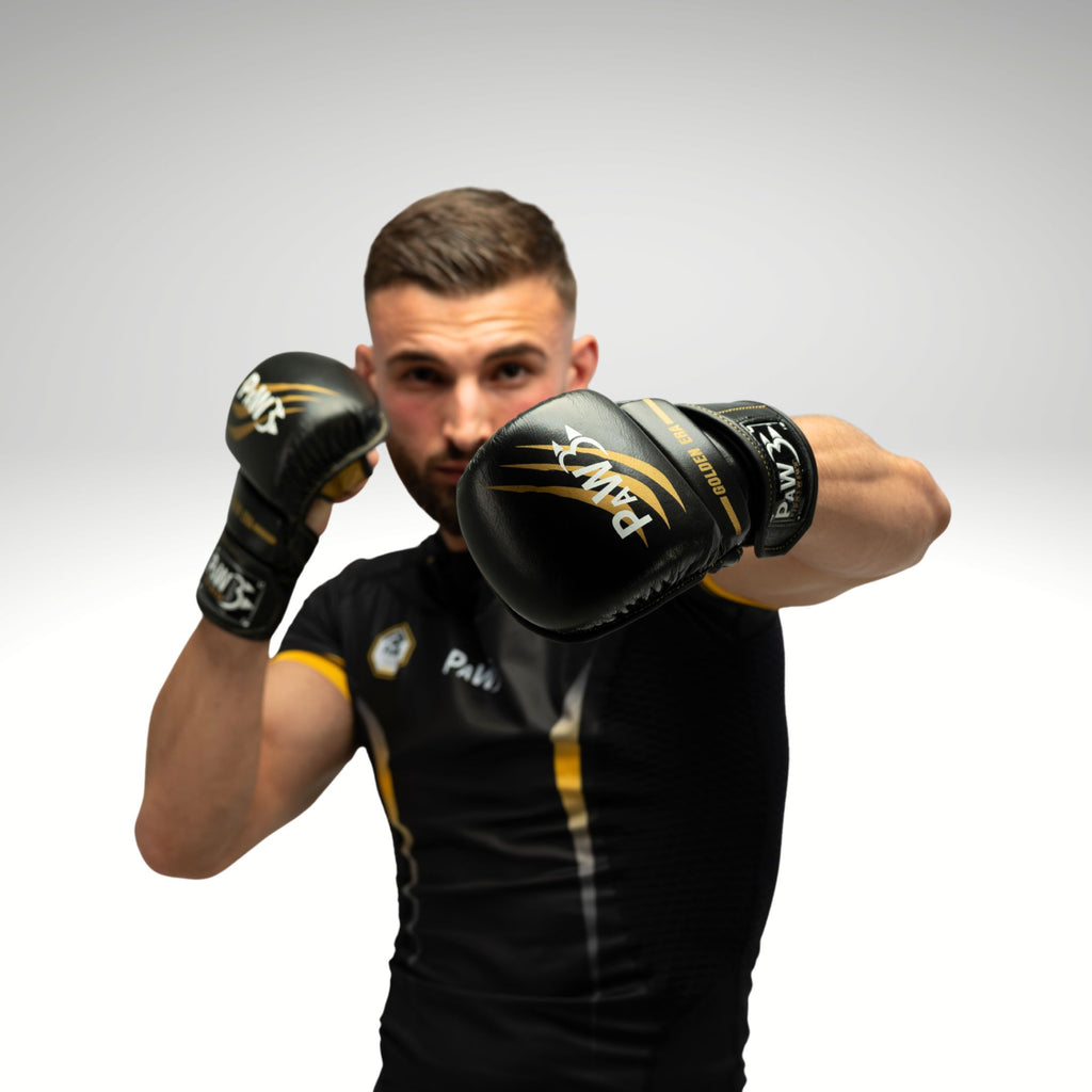 Mann mit PAW MMA Handschuhen und schwarzem Compression Shirt – Kampfsportbekleidung für MMA und Training