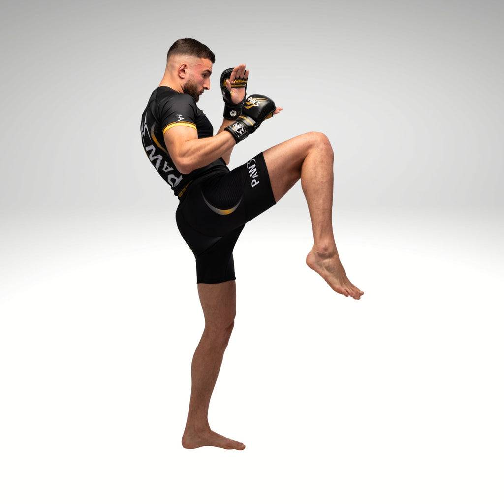 MMA Kämpfer mit PAW MMA Handschuhen, Compression Shirt und Shorts beim Knie-Kick – Kampfsportbekleidung für MMA Training