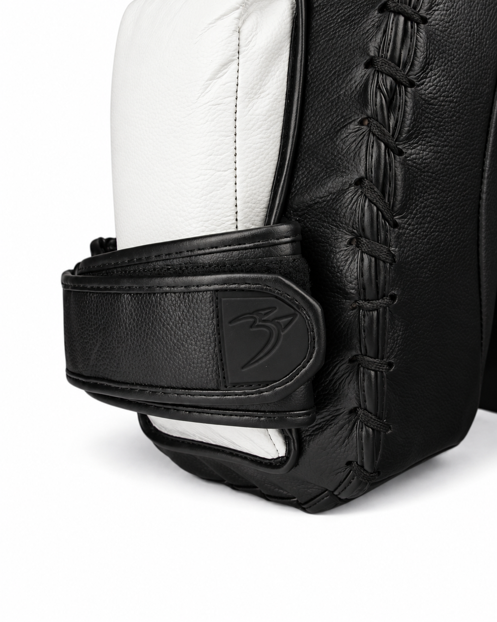 Detailaufnahme des verstellbaren Klettverschlusses der PAW PBS-Crush Muay Thai Pads mit weißer Innenpolsterung, verstärkter Schnürung und schwarzem Lederbezug.