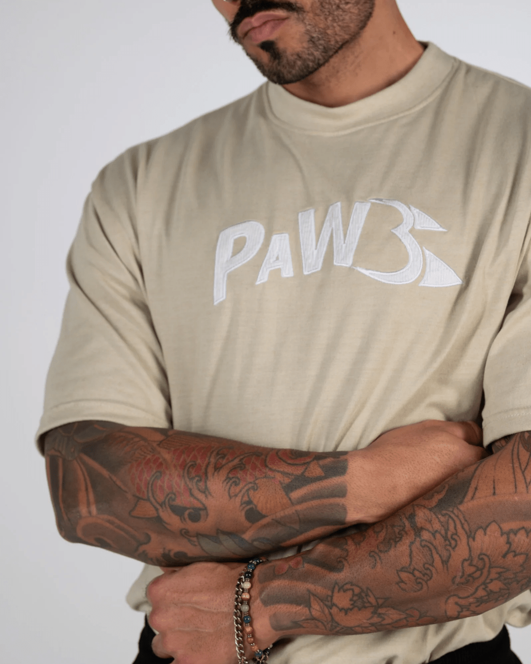 PAW Fightwear Logo auf beigem Oversize Shirt – Detailansicht des Unisex T-Shirts